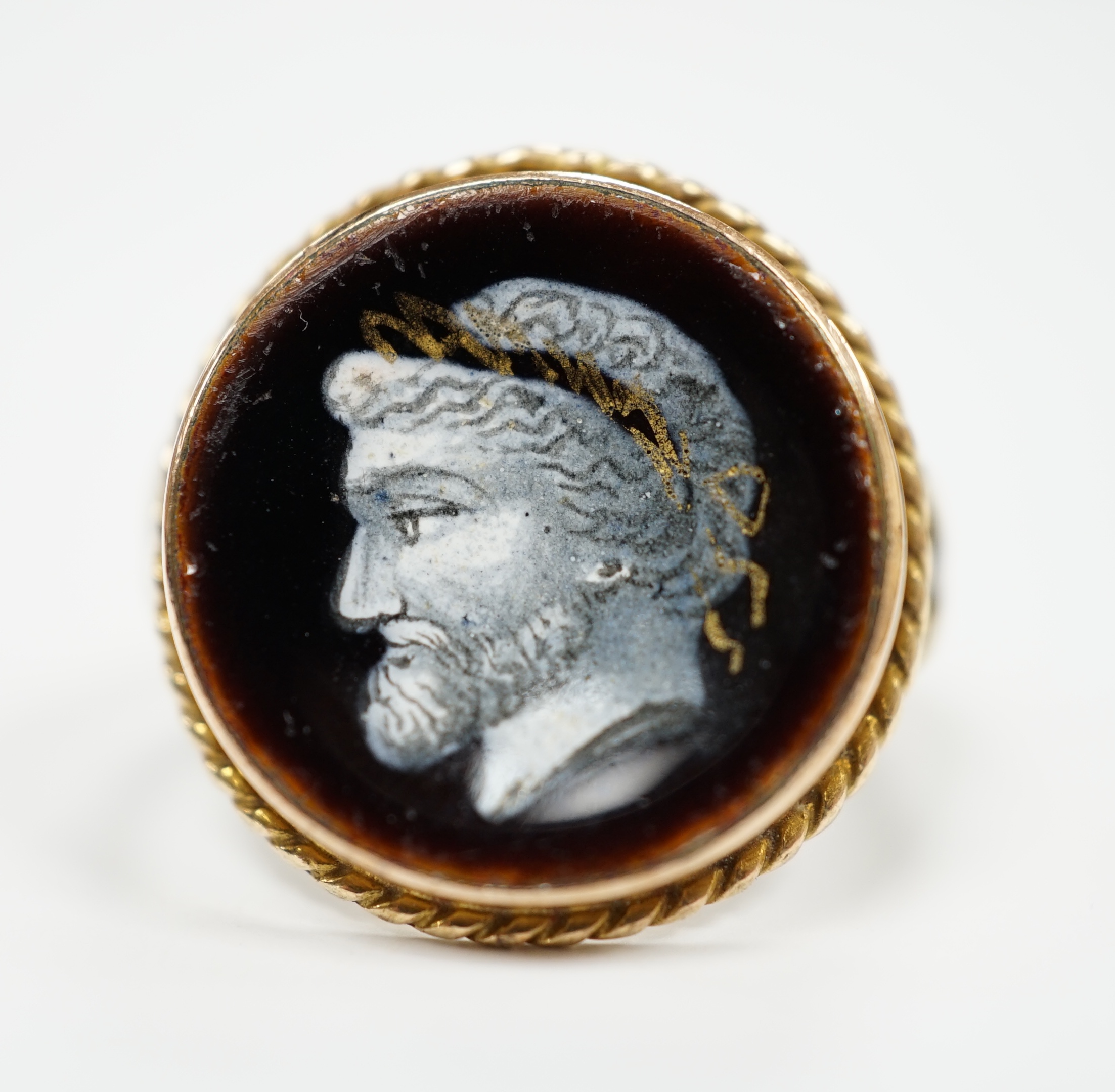An antique 9ct and enamel set circular ring, depicting the head of a gentleman to dexter, size G, gross weight 3.2 grams.